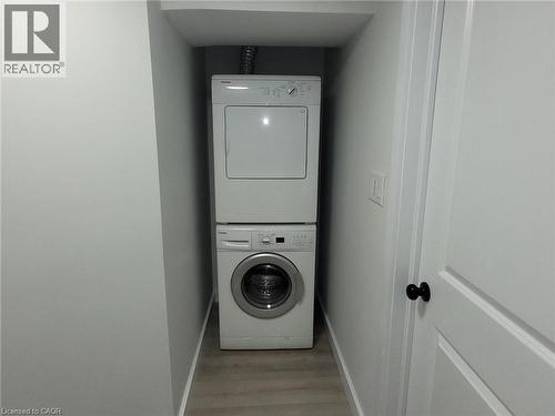 Stacked washer and dryer unit in a dedicated laundry alcove - 132 East 31St Street, Hamilton, ON - Indoor Photo Showing Laundry Room