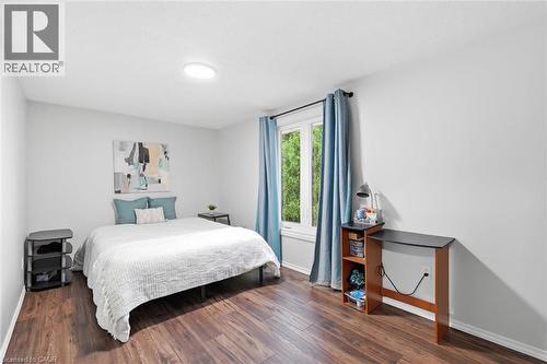 Bedroom featuring wood-finish flooring, white walls, and a large window - 450 East 42Nd Street, Hamilton, ON - Indoor Photo Showing Bedroom