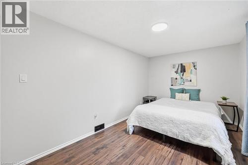 Bright secondary bedroom featuring wood-finish flooring, recessed ceiling lighting, and built-in shelving with teal accent backing - 450 East 42Nd Street, Hamilton, ON - Indoor Photo Showing Bedroom
