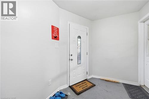 Entryway featuring a white door with decorative glass inserts, light gray walls, and gray flooring - 450 East 42Nd Street, Hamilton, ON - Indoor Photo Showing Other Room