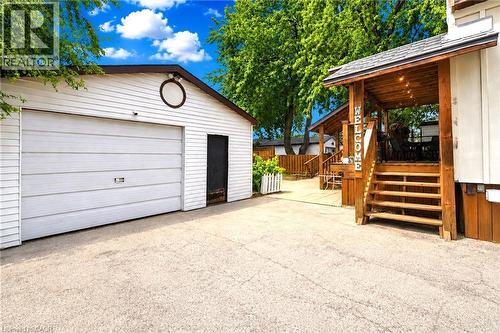Spacious driveway with detached single-car garage featuring a white overhead door and side entry - 450 East 42Nd Street, Hamilton, ON - Outdoor With Exterior
