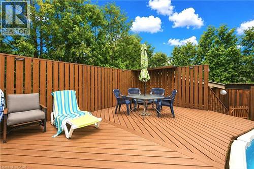 Expansive composite deck featuring warm wood-finish decking with diagonal pattern detail, cedar-tone railings, and mature tree canopy backdrop - 450 East 42Nd Street, Hamilton, ON - Outdoor With Exterior