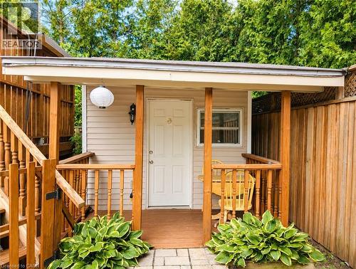 Charming covered front entry featuring a white-painted entry door with sidelights, flanked by substantial wooden support posts and railings - 450 East 42Nd Street, Hamilton, ON - Outdoor With Exterior