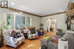 Living area featuring wood-finish flooring and a decorative border along the ceiling line - 
