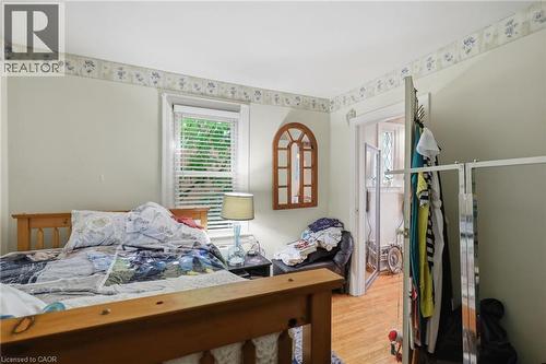 Bedroom featuring wood-finish flooring, a window with blinds, and decorative wallpaper border - 356 Thompson Road, London, ON - Indoor Photo Showing Bedroom