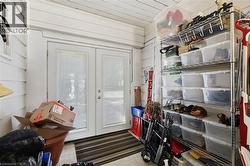 Utility room featuring sliding glass doors with natural light, wall-mounted shelving with clear storage containers, pegboard organization system, and striped floor runner - 