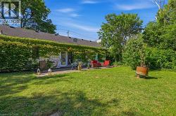 Expansive backyard featuring a manicured lawn and mature trees - 