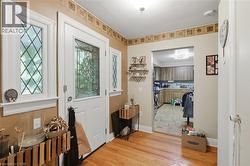 Welcoming entry foyer featuring hardwood flooring, decorative tile border detail, and white trim work throughout - 