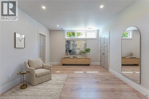 Bright, open room showcasing gleaming wood-finish flooring, recessed ceiling lighting, and abundant natural light from transom windows - 986 Highway 8, Hamilton, ON - Indoor