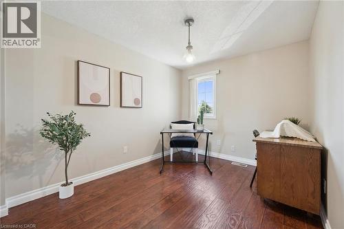 Bright and airy office space featuring rich wood-finish flooring, clean white walls, and abundant natural light from a large window - 86 Bridlewreath Street, Kitchener, ON - Indoor