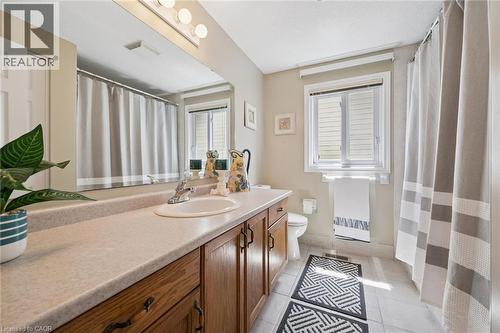 Spa-inspired primary bathroom featuring a wood-finish vanity with dual sinks, quartz countertops, and polished chrome fixtures - 86 Bridlewreath Street, Kitchener, ON - Indoor Photo Showing Bathroom