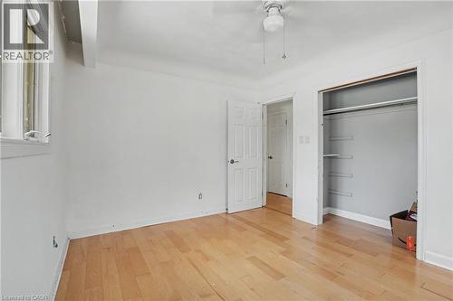 Room featuring wood-finish flooring, white walls, and a window with a white frame - 100 Hardale Crescent, Hamilton, ON - Indoor Photo Showing Other Room