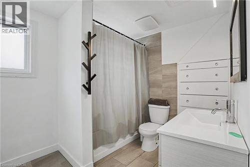 Bathroom featuring a white vanity with integrated sink, chrome faucet, tiled shower surround, recessed lighting, and a window for natural light - 100 Hardale Crescent, Hamilton, ON - Indoor Photo Showing Bathroom