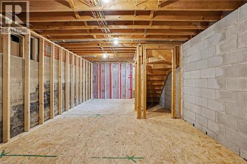 Unfinished basement offering expansive space with wood framing, exposed ceiling joists, electrical conduit, concrete block wall, and subflooring - 100 Hardale Crescent, Hamilton, ON - Indoor Photo Showing Basement