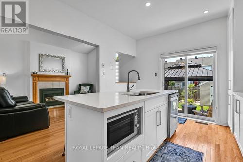 Kitchen with adjacent Family room & access to yard - 4121 Wolfe Point Way, Ottawa, ON - Indoor With Fireplace