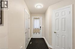 Foyer featuring light-toned walls, white trim, and light-colored flooring - 