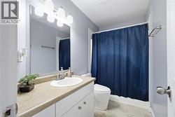 Modern bathroom featuring a floating vanity with wood-finish countertop, round vessel sink, and chrome fixtures - 