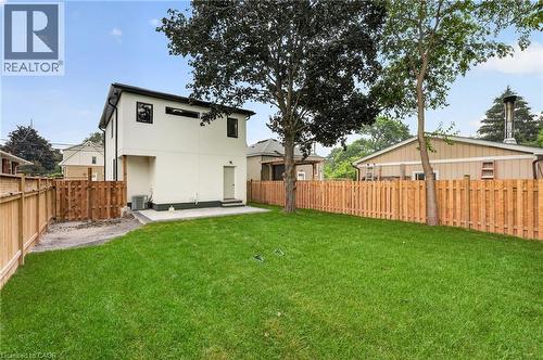 Expansive rear yard featuring a manicured lawn, established trees, and newly installed wood privacy fencing - 325 Queensdale Avenue E, Hamilton, ON - Outdoor