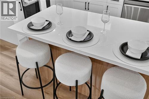 Kitchen island with a white countertop and light wood-finish base - 325 Queensdale Avenue E, Hamilton, ON - Indoor Photo Showing Dining Room