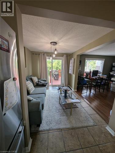 Open-concept living area featuring tile flooring, recessed ceiling lighting, and glass sliding doors opening to an outdoor patio - 466 Bankside Drive, Kitchener, ON - Indoor Photo Showing Other Room