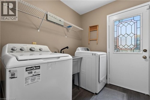 Main floor laundry room includes an exterior door to side rear yard, as well as to the garage, and stairs to basement. - 3194 Tania Crescent, Burlington, ON - Indoor Photo Showing Laundry Room