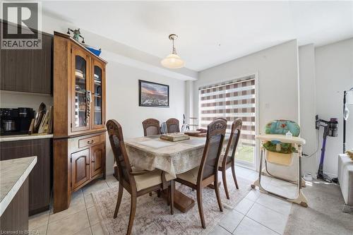 Dining area featuring a sliding glass door with horizontal blinds, overhead lighting, and tile flooring - 32 Cole Crescent, Brantford, ON - Indoor Photo Showing Dining Room