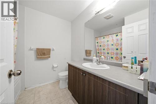 Bathroom featuring a wood-finish vanity with an integrated sink and laminate countertop - 32 Cole Crescent, Brantford, ON - Indoor Photo Showing Bathroom