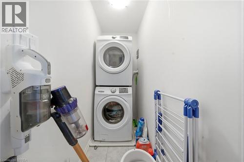 Dedicated laundry area featuring a stacked washer and dryer - 32 Cole Crescent, Brantford, ON - Indoor Photo Showing Laundry Room
