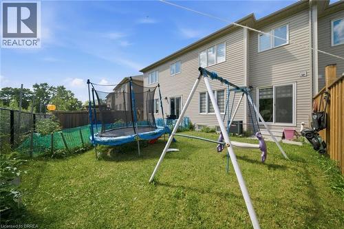 Expansive rear yard featuring green lawn space, a wooden privacy fence, and chain link fencing - 32 Cole Crescent, Brantford, ON - Outdoor