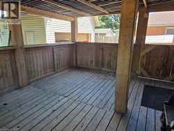 Covered wood deck with slatted wood flooring, wood post and rail construction, and a corrugated roof - 