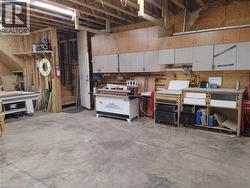 Spacious workshop area featuring exposed ceiling joists and concrete flooring - 