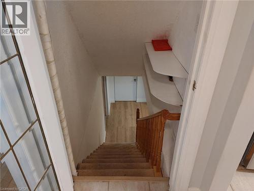 Staircase with carpeted treads and a wood-finish handrail, complemented by a built-in shelving unit - 76 Brentwood Avenue, Kitchener, ON - Indoor Photo Showing Other Room