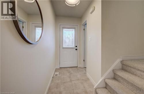 Entryway featuring ceramic tile flooring, a white paneled door with decorative glass, and a carpeted staircase - 496 Langlaw Drive, Cambridge, ON - Indoor Photo Showing Other Room