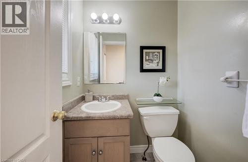 Bathroom featuring a wood-finish vanity with a laminate countertop, a white oval sink, and a chrome faucet - 496 Langlaw Drive, Cambridge, ON - Indoor Photo Showing Bathroom