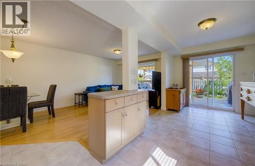 Spacious room featuring tile flooring, a kitchen island with storage, and sliding glass doors providing access to the exterior - 496 Langlaw Drive, Cambridge, ON - Indoor
