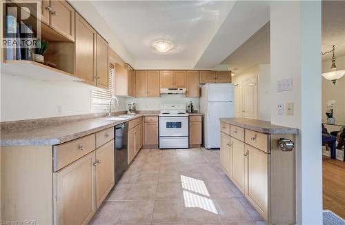 Kitchen featuring light wood-finish cabinetry, a double basin stainless steel sink, and a white electric range - 496 Langlaw Drive, Cambridge, ON - Indoor Photo Showing Kitchen