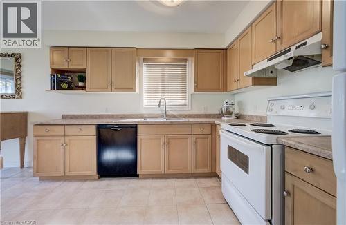 U-shaped kitchen with wood-finish cabinetry and light-toned countertops - 496 Langlaw Drive, Cambridge, ON - Indoor Photo Showing Kitchen