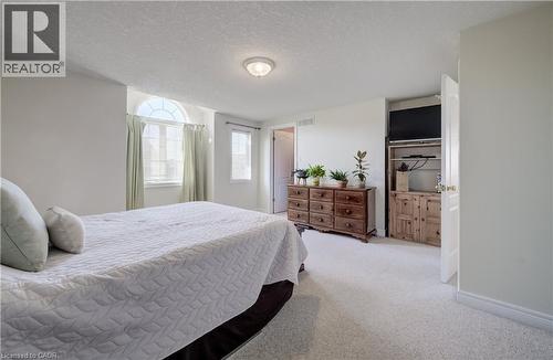 Spacious room featuring light-colored carpeting, a vaulted ceiling, and an arched window - 496 Langlaw Drive, Cambridge, ON - Indoor Photo Showing Bedroom