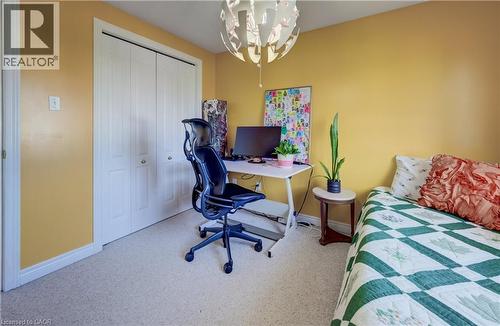 Recessed closet with white bi-fold doors, light-colored carpeting, and a unique overhead light fixture - 496 Langlaw Drive, Cambridge, ON - Indoor Photo Showing Other Room