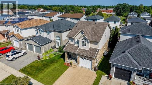 Two-story residence featuring a front gabled roof, light beige siding, and stone veneer accents - 496 Langlaw Drive, Cambridge, ON - Outdoor