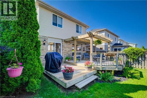 Rear exterior featuring a multi-level wood deck with pergola, sliding glass door access, and a wood fence enclosure - 496 Langlaw Drive, Cambridge, ON - Outdoor With Deck Patio Veranda