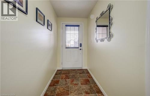Entryway featuring a white door with integrated blinds, square multi-tone floor tiles, and neutral-toned walls - 521 Snowdrop Court, Kitchener, ON - Indoor Photo Showing Other Room