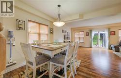 Open-concept dining and living area featuring wood-finish flooring, recessed lighting, and a sliding glass door to the exterior - 