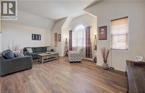 Living area featuring wood-finish flooring, vaulted ceilings, and ample natural light from multiple windows - 521 Snowdrop Court, Kitchener, ON - Indoor