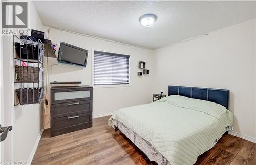 Room featuring wood-finish flooring, white walls, and a ceiling-mounted light fixture - 521 Snowdrop Court, Kitchener, ON - Indoor Photo Showing Bedroom