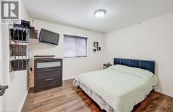 Room featuring wood-finish flooring, white walls, and a ceiling-mounted light fixture - 