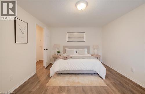 Neutral tone walls complement wood-finish flooring - 521 Snowdrop Court, Kitchener, ON - Indoor Photo Showing Bedroom