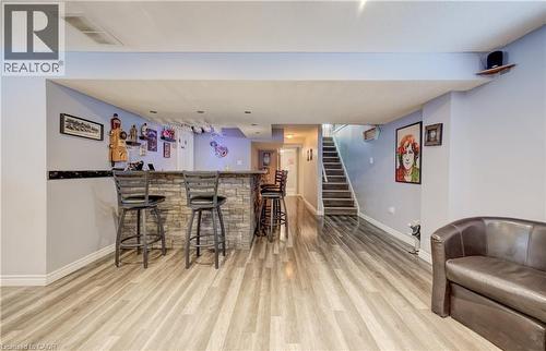 Finished lower level with wood-finish flooring and a stone-clad bar - 521 Snowdrop Court, Kitchener, ON - Indoor