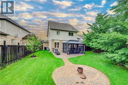 Expansive backyard featuring a manicured lawn, a stamped concrete patio, and a covered gazebo - 521 Snowdrop Court, Kitchener, ON - Outdoor With Deck Patio Veranda