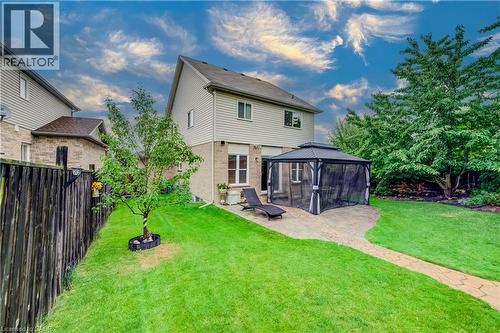 Expansive backyard featuring a stone patio, a gazebo with screens, and a lush green lawn - 521 Snowdrop Court, Kitchener, ON - Outdoor